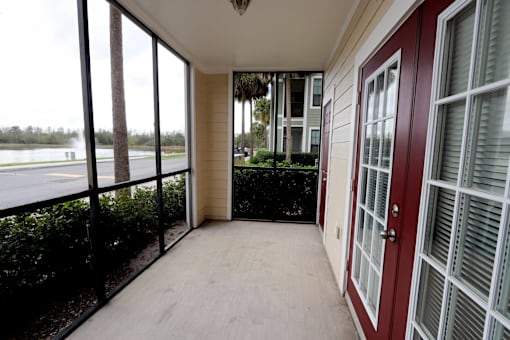 A balcony with a view of a body of water and trees.