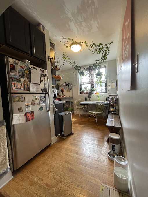 A kitchen with a refrigerator covered in magnets and a dining table with chairs.