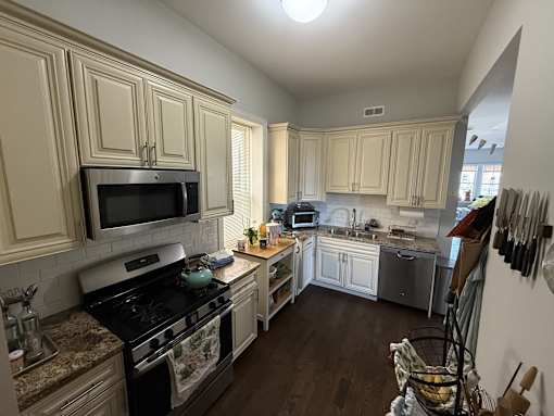 A kitchen with a black stove top oven and a microwave above it.