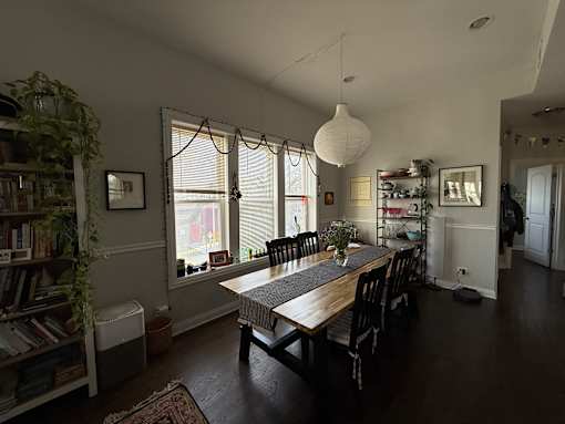 A dining room with a long table and chairs.