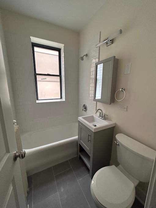 A bathroom with a toilet, sink, and bathtub.