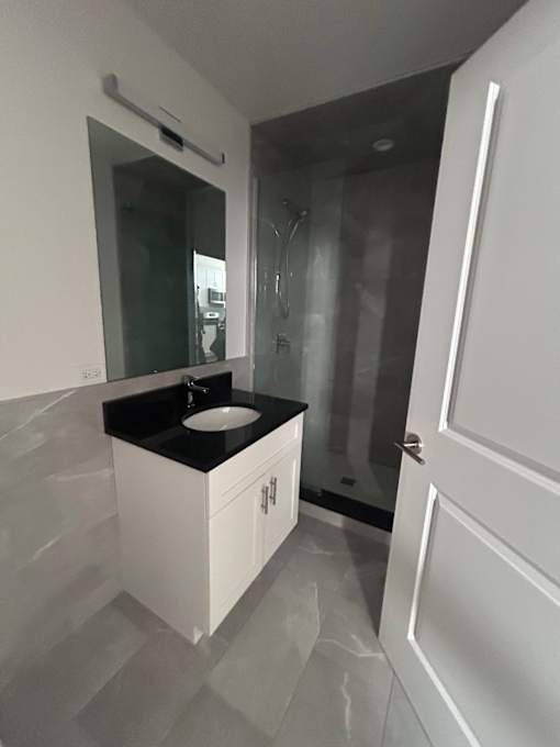 A bathroom with a sink and a shower.