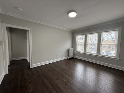 A room with a wooden floor and a window.