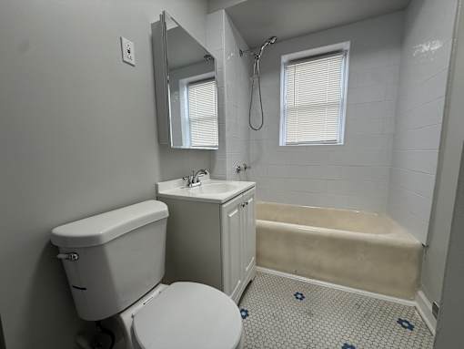 A white toilet sits next to a sink in a small bathroom.