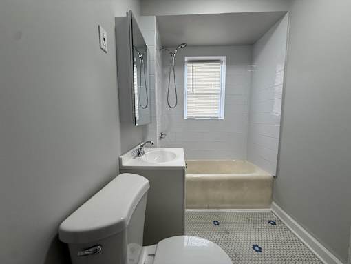 A white toilet sits next to a sink in a small bathroom.
