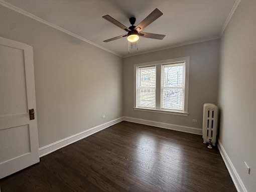 A room with a ceiling fan and a window.