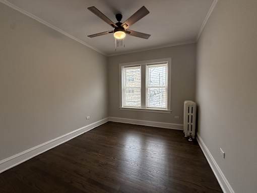 A room with a ceiling fan and a window.