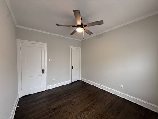 A room with a ceiling fan and wooden floors.