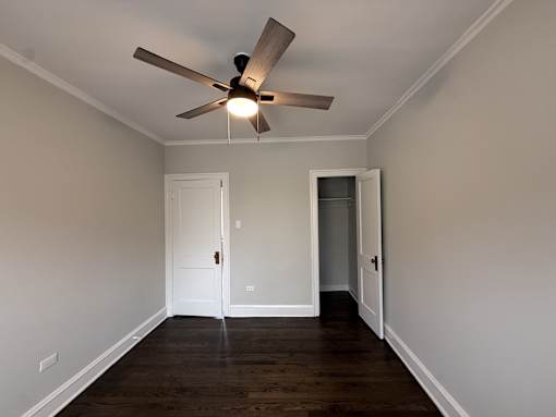 A room with a ceiling fan and two doors.