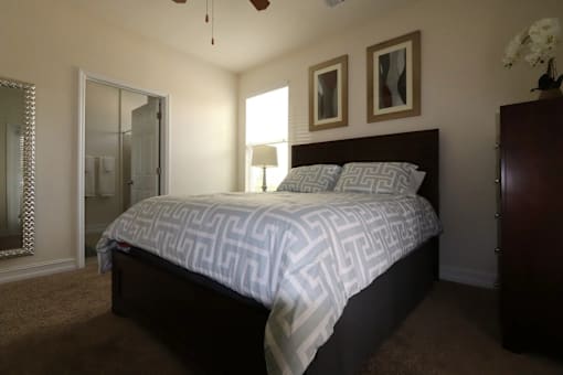 A bedroom with a bed, dresser, and mirror.