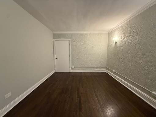 A room with a wooden floor and a white door.
