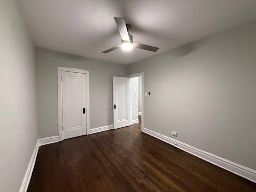 A room with wooden floors and a ceiling fan.