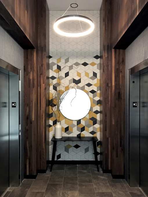A hallway with a bench and two elevators.