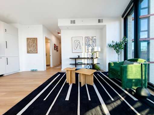 A black and white striped rug is on the floor of a modern living room.