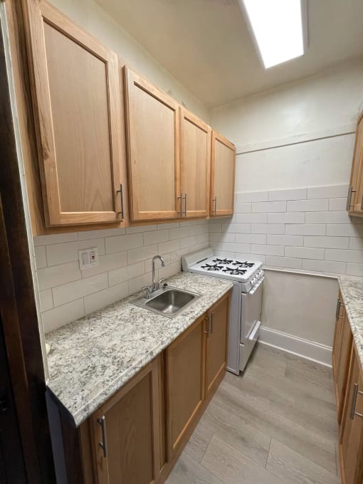 a kitchen with wooden cabinets and granite counter tops and a stove and sink