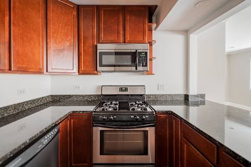 A kitchen with a black stove top oven and microwave above it.