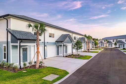 A row of houses with a tree in front of the first one.