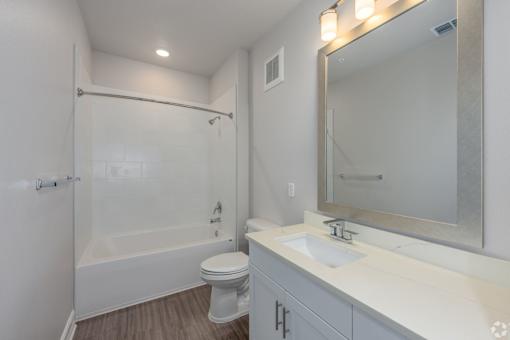 A white bathroom with a toilet, sink, and shower.