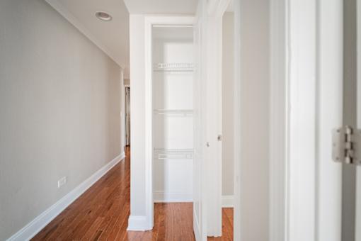 A long hallway with white walls and wood floors.
