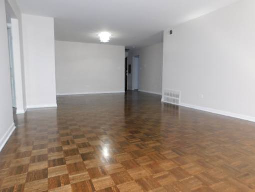 A room with wooden flooring and white walls.