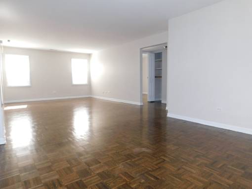 A room with wooden flooring and white walls.