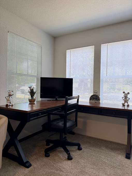 A black entertainment center with a flat screen TV and a glass shelf underneath it.