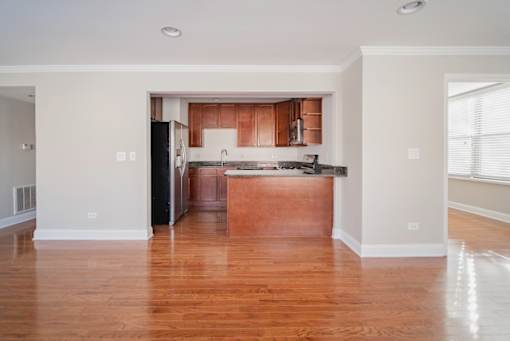 A kitchen with wooden floors and white walls.
