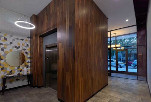 A wooden room with a round mirror and a tiled wall.
