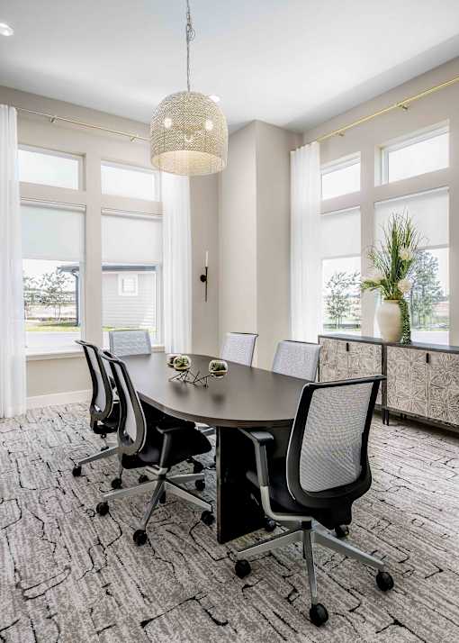 A conference room with a table and chairs.