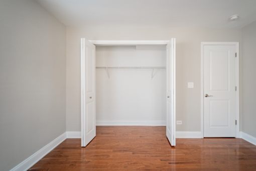 A room with a white door and a white wardrobe.