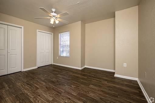 A room with wooden flooring and a ceiling fan.