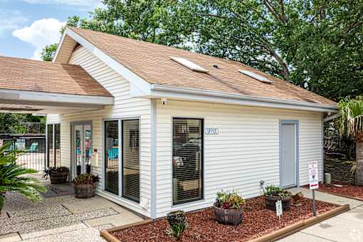A small white building with a brown roof and a sign that says "EXIT".