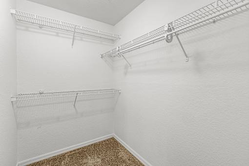 Empty white closet with shelves and carpet.