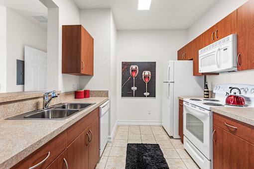 A kitchen with white appliances and wooden cabinets.