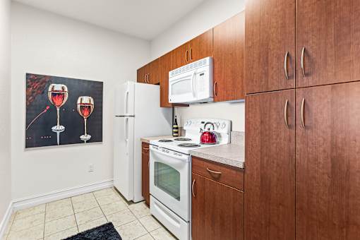 A kitchen with brown cabinets and a fridge.
