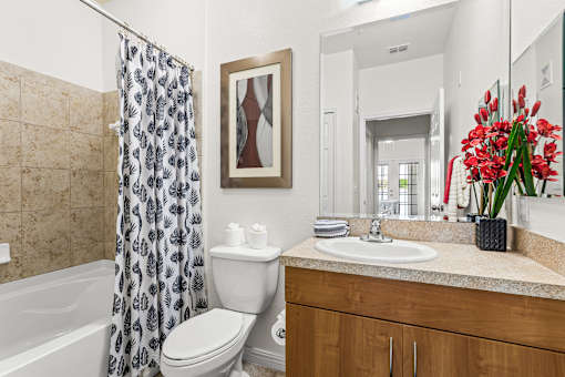 A bathroom with a toilet, sink, and shower.