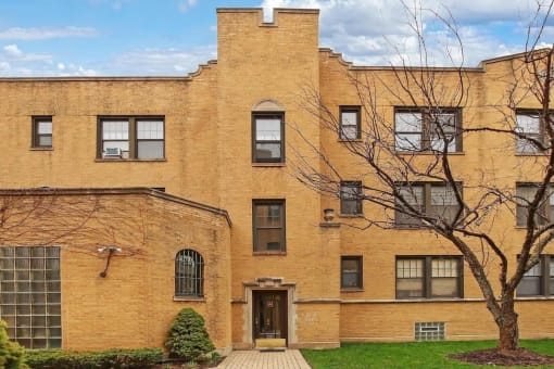 a brick building with a tree in front of it