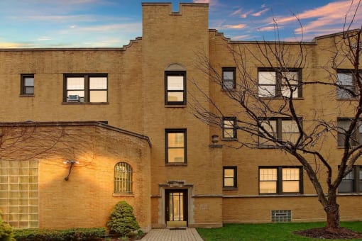 a large brick building with a tree in front of it