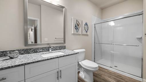 A bathroom with a toilet, sink, and shower.