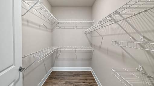 Empty walk-in pantry with white walls and shelving.