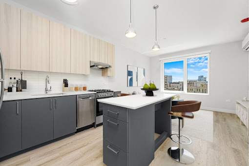 A kitchen with a large island and a view of the city.