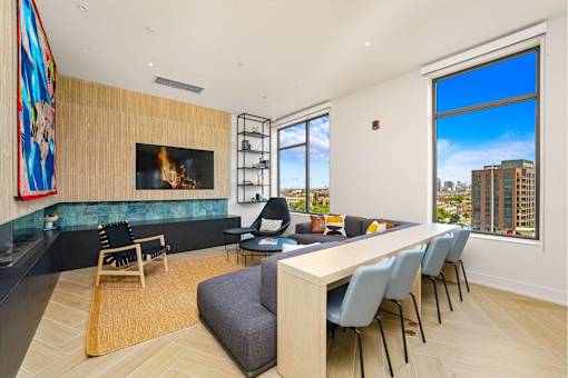A modern living room with a fireplace and a long table.