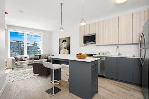 A modern kitchen with a large island and a view of the city.