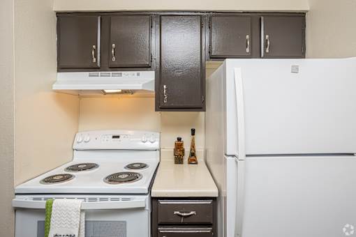 A kitchen with a white fridge, white stove and white oven.