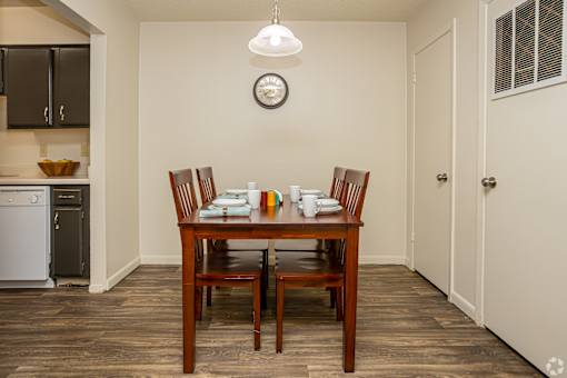 A dining room with a wooden table and chairs.