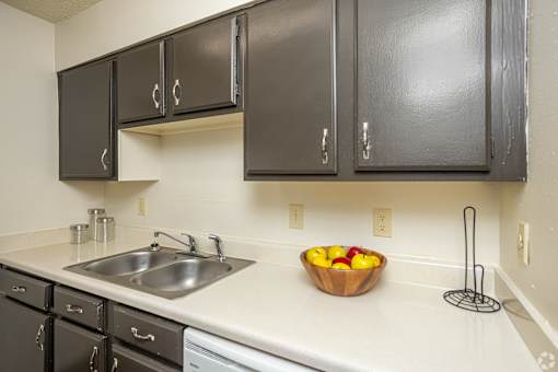 A kitchen with a bowl of fruit on the counter.