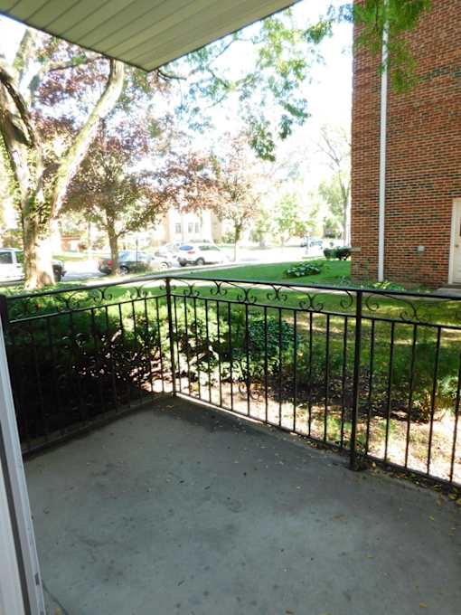 A black metal fence surrounds a concrete patio.