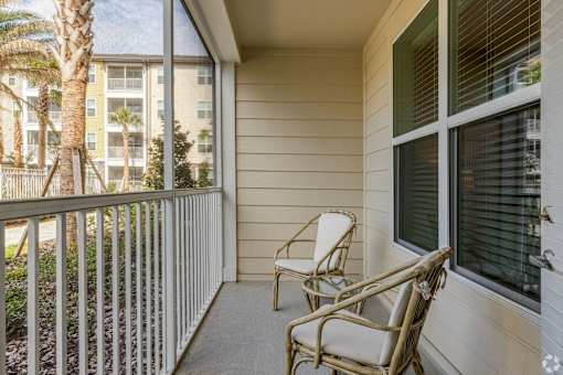 A balcony with a chair and a railing.