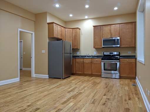 A kitchen with wooden floors and a refrigerator.