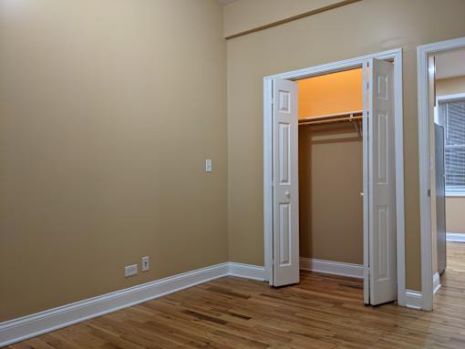 A room with a white door is open to another room.